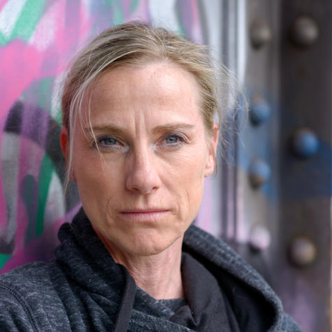 Woman Wearing Hoodie Against Graffiti Wall